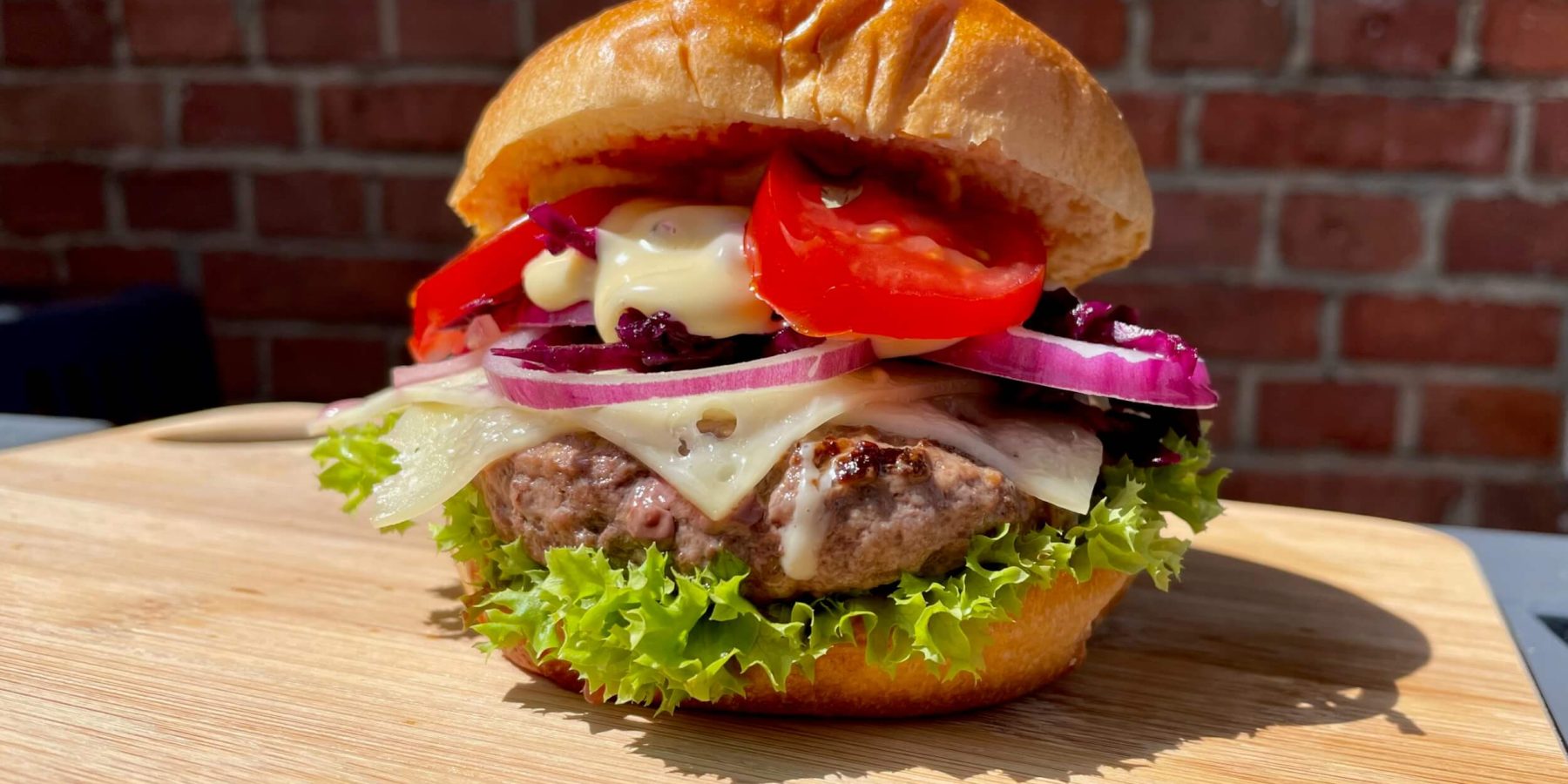 Ein knackiges Burger-Foto mit rustikalem Hintergrund